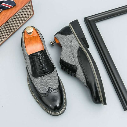Pair of black and gray patterned dress shoes on a light gray background