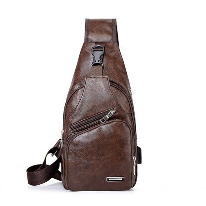 Light brown leather chest bag with top handle, front zip pocket, and logo plate