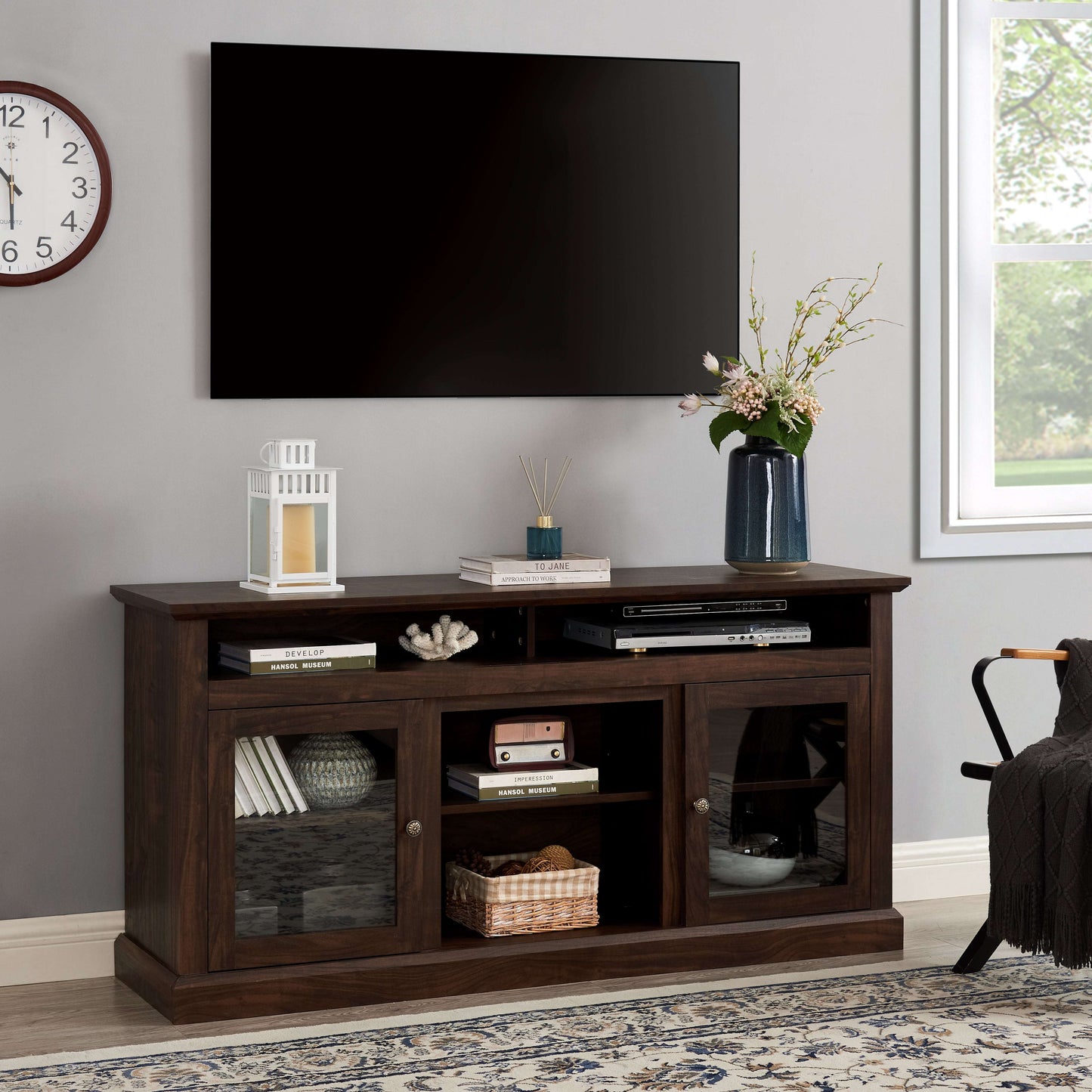 Brown farmhouse TV stand with open shelves and two-door storage, vase and lamp on top.
