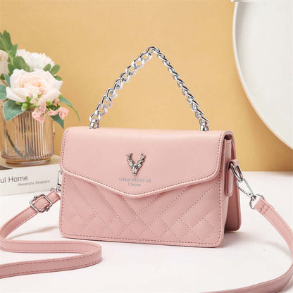 Blush pink quilted mini crossbody bag with flap and chain strap, butterfly emblem