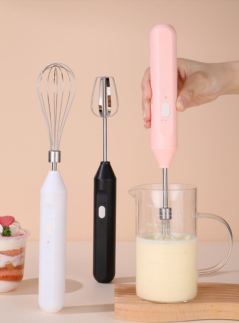 Set of three handheld mixers in white, black, and pink on a beige background.