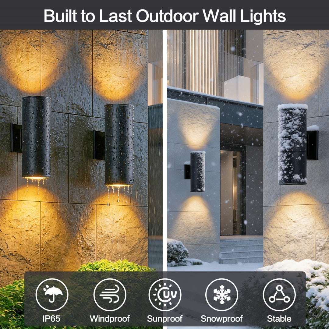 Matte black cylinder outdoor wall lights on stone facade with warm upward glow