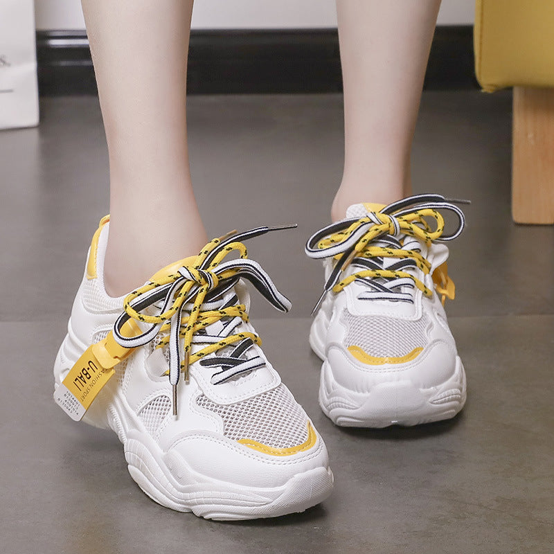White mesh lightweight sneakers with yellow laces and trim, chunky cushioned sole, lace-up.