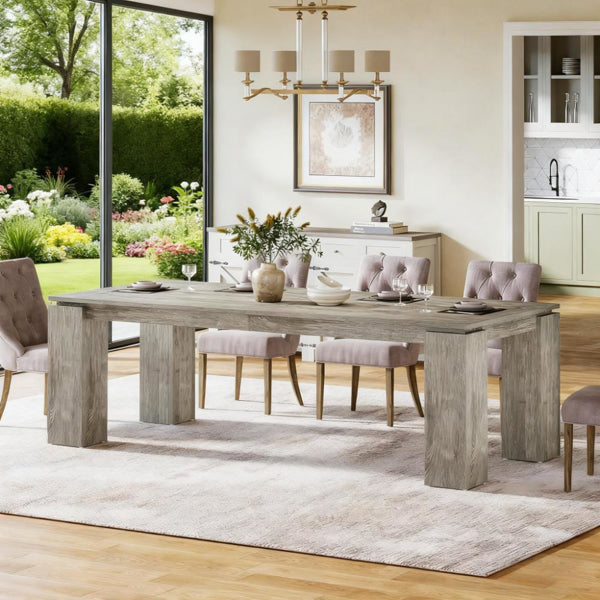 Rectangular light gray wood dining table with four thick legs in an indoor setting