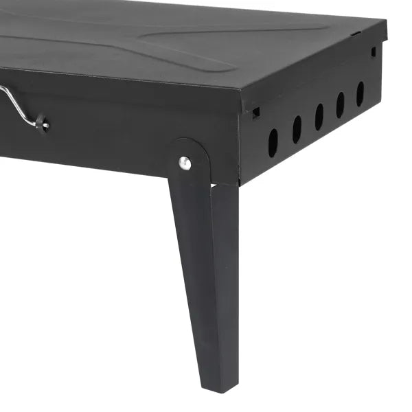 Black metal side view of portable square charcoal grill with vent holes and legs