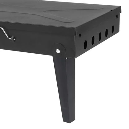 Black metal side view of portable square charcoal grill with vent holes and legs