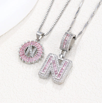 Silver pendant necklace set with pink crystal flower pendant and large letter charm, side view