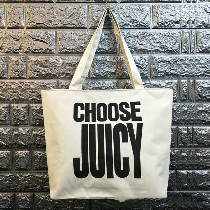Canvas shoulder bag with bold black “CHOOSE JOY” lettering on cream canvas