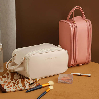 Cream cosmetic bag with double zippers beside a pink matching cosmetic bag