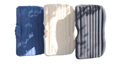 Inflatable car mattress shown in dark blue, off-white, and dark gray with pillows