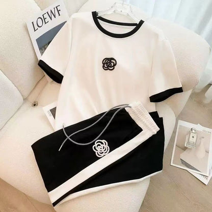 Women's two-piece set: white tee with black cuffs and logo, plus black drawstring wide-leg pants