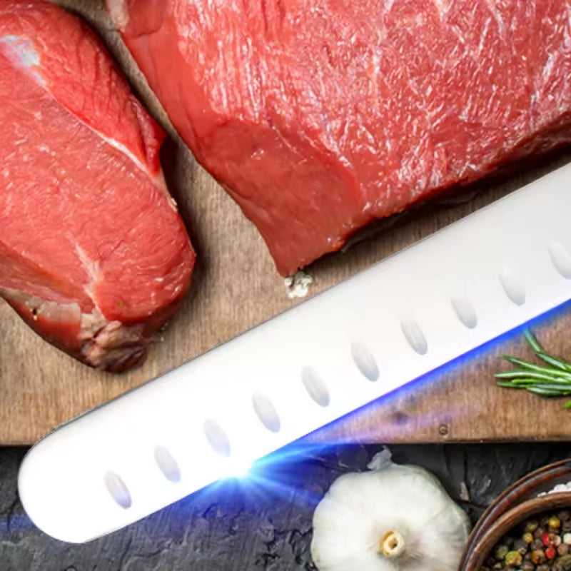Carbon steel chef knife, white blade with dimples, dark handle, blue edge reflection