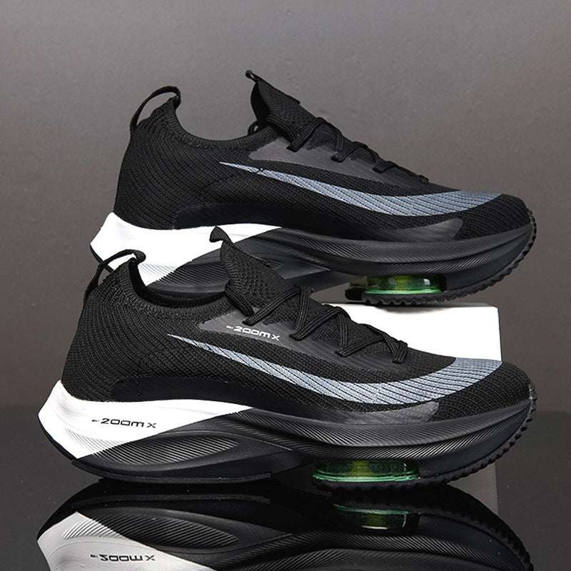 A pair of men's sports shoes with black, green, and gray colors featuring a lace-up closure and a thick sole.
