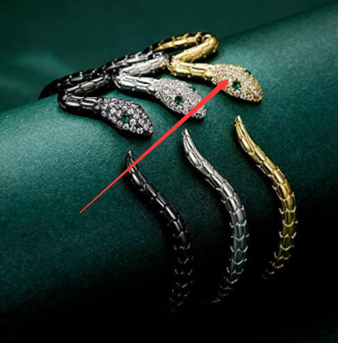 Multiple snake bracelets in black, silver, and gold-tone with zircon embellishments