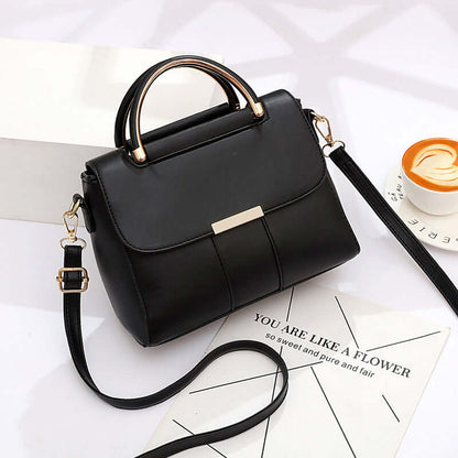Black structured crossbody bag with flap closure, top handle, and long shoulder strap