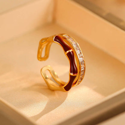Gold-tone open ring with red enamel and a row of zircon stones