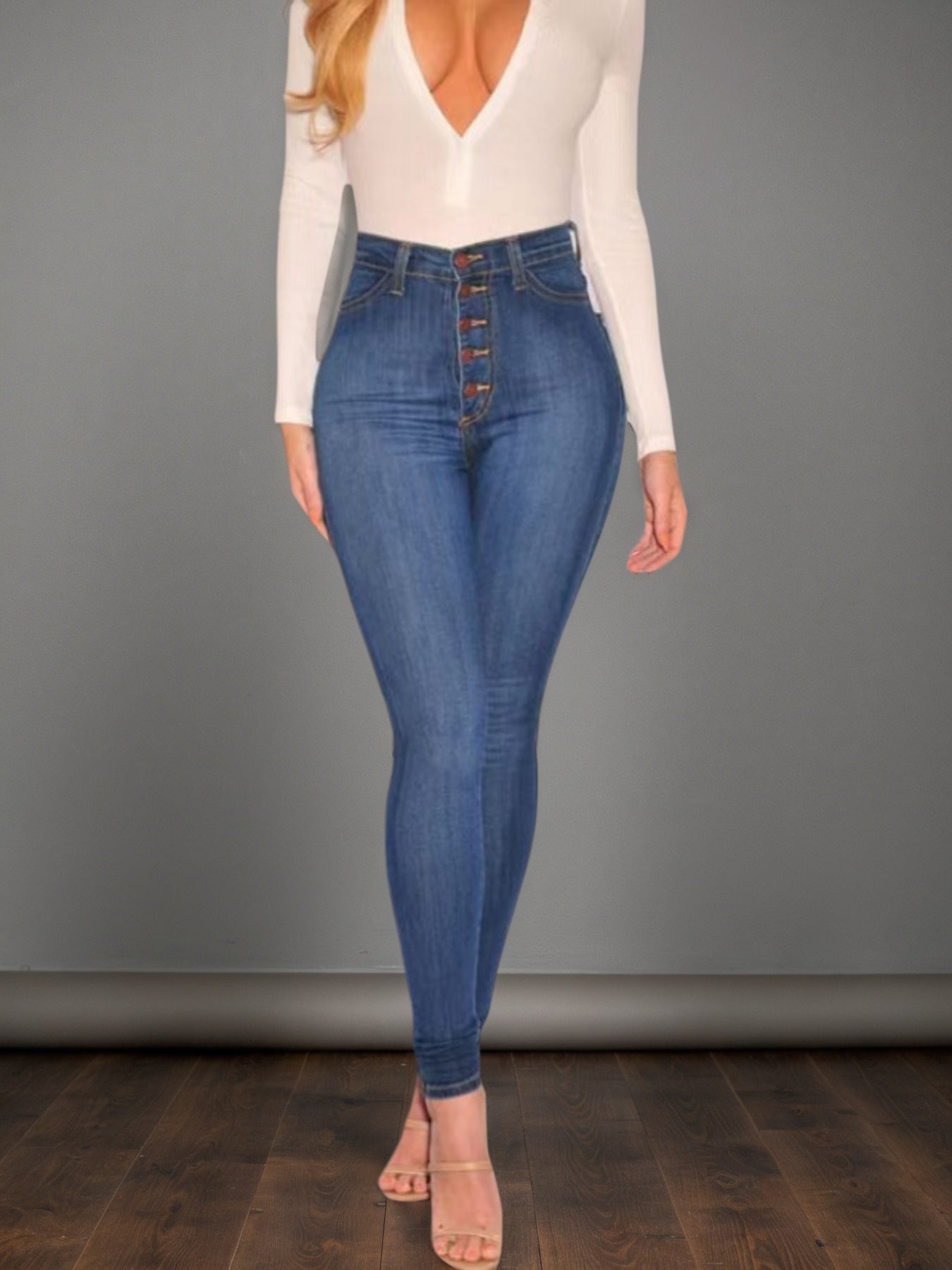 Women’s mid-blue high-waisted buckle jeans, front view with dark button fly and fitted legs