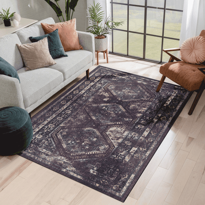 Washable area rug with distressed geometric medallion pattern in dark black and muted burgundy