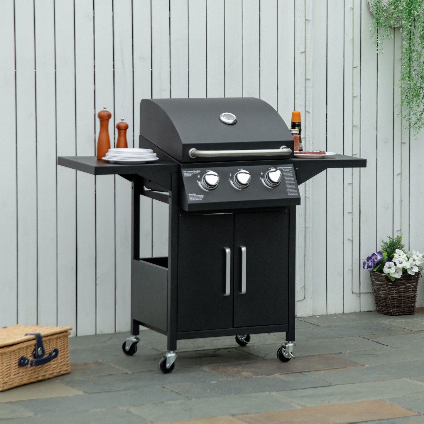 Black 3-burner gas grill with lid, control knobs, side shelves, and caster wheels