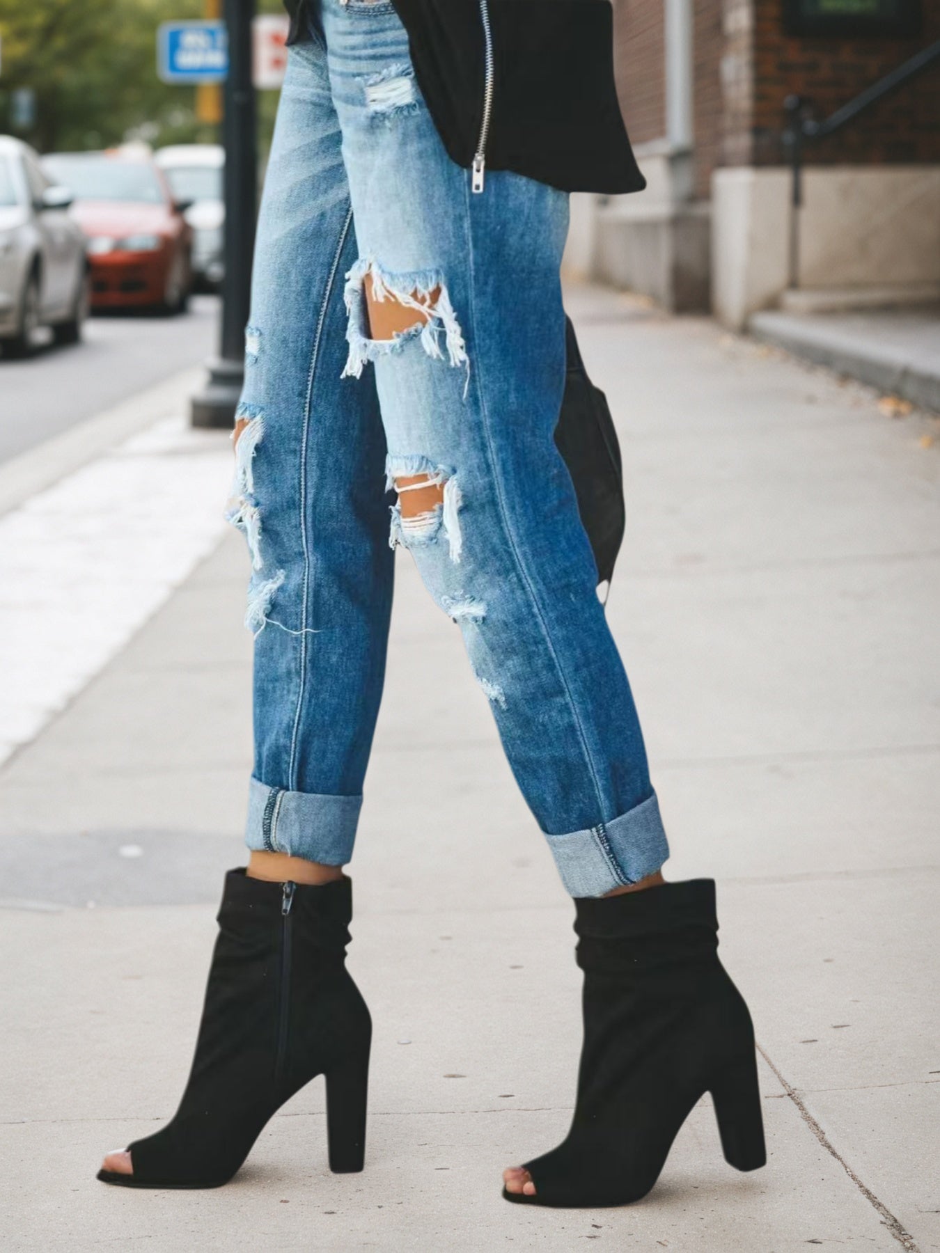 Light blue low-rise ripped jeans with vertical patch rips and cuffed hem