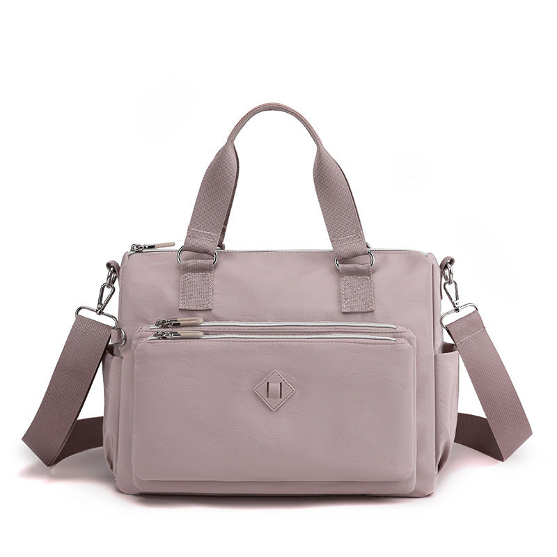 Waterproof nylon one-shoulder bag in light purple, front zip pocket, adjustable strap