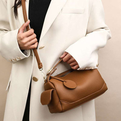 Dark brown leather crossbody pillow bag with front flap and long shoulder strap