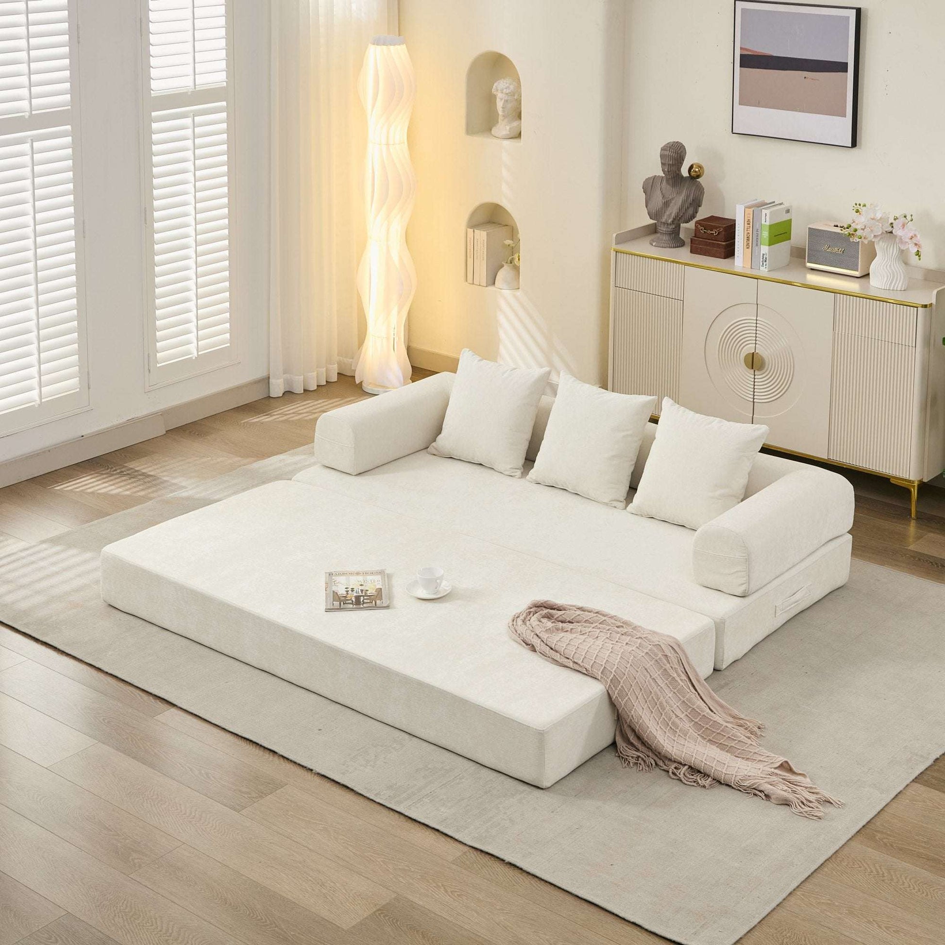 Beige convertible sofa bed, side view with extended sleeping surface and three back pillows