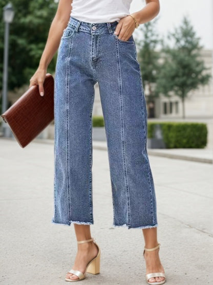 Blue plus-size wide-leg jeans with high rise, button fly, and frayed cropped hem