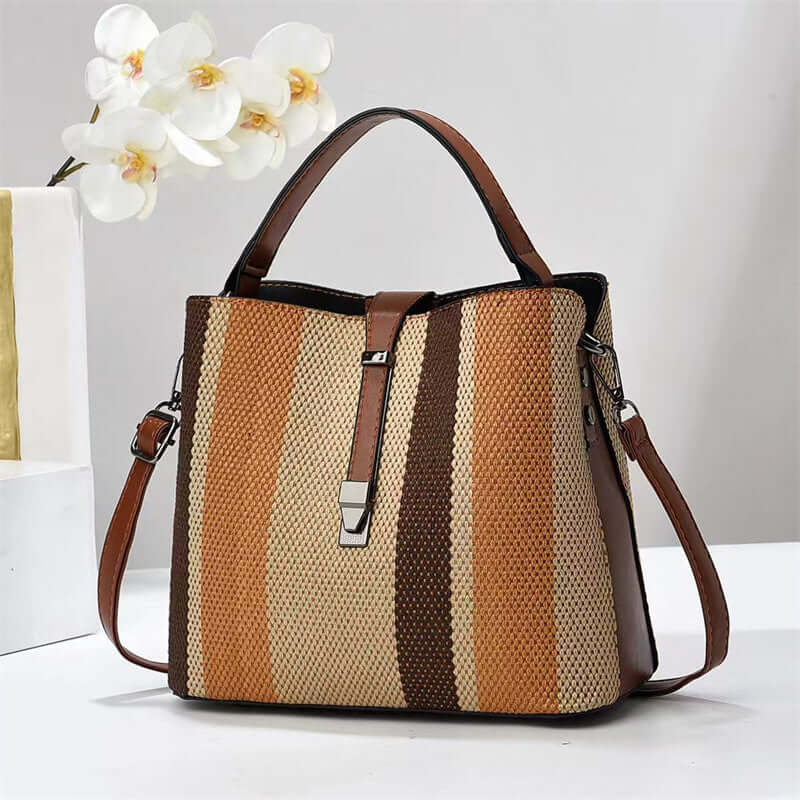 Striped PU crossbody handbag with top handles, brown trim, and front zip pocket