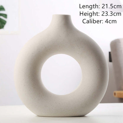 Off-white ceramic vase with large circular cutout, rounded base and short neck
