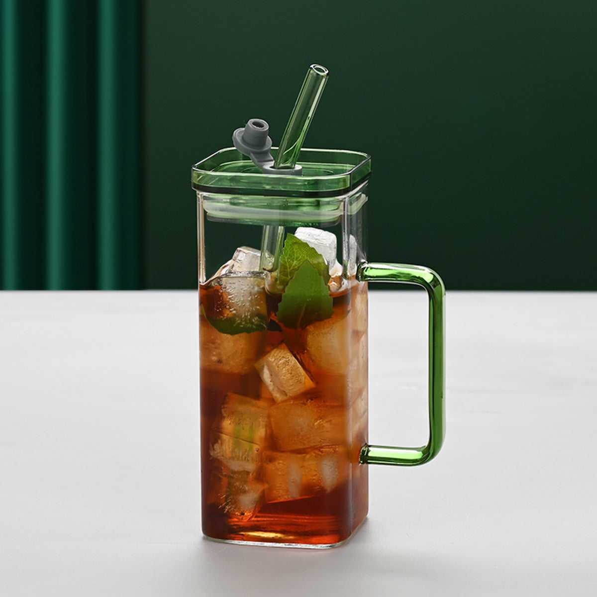 Square glass cup with green handle, green lid, and straw