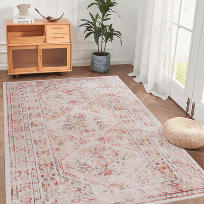Cream area rug with red and blue ornate border and medallion pattern on hardwood floor