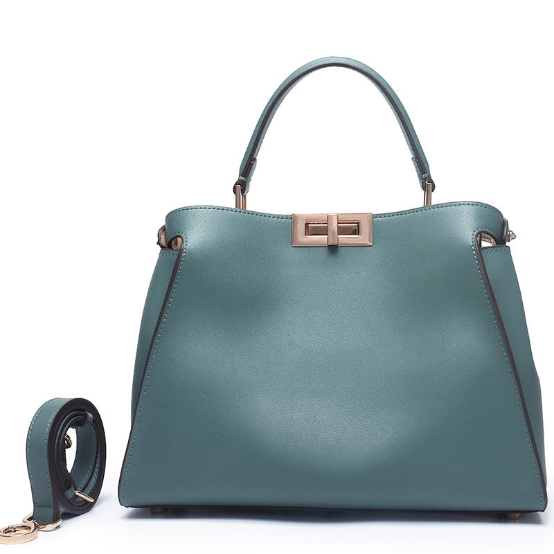 Teal crossbody handbag with metal clasp, top handles, and adjustable crossbody strap