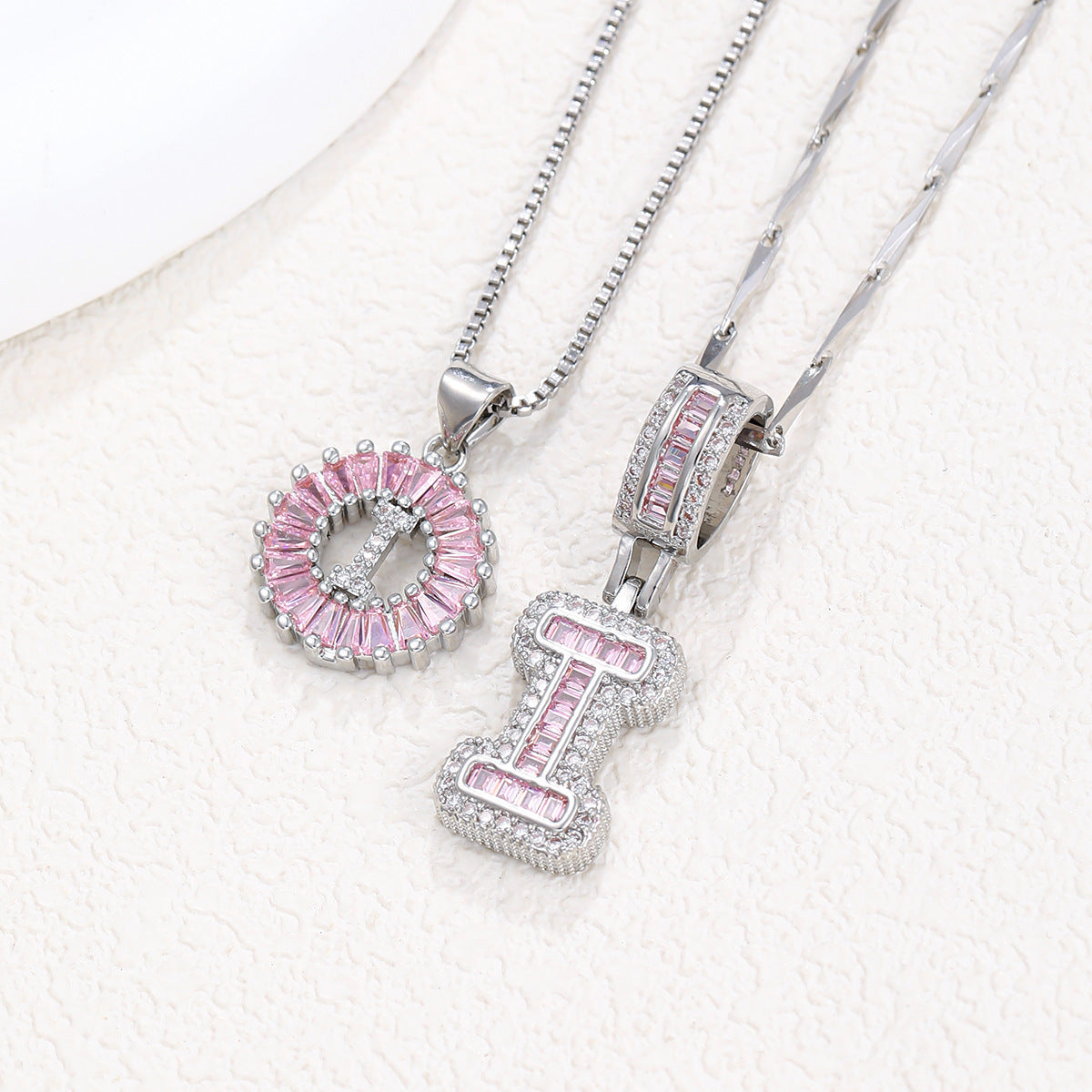 Silver pendant necklace set with pink crystal flower charm and letter charm, two necklaces shown