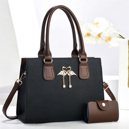 Black large crossbody tote bag with brown handles, front heart charm, and side pouch