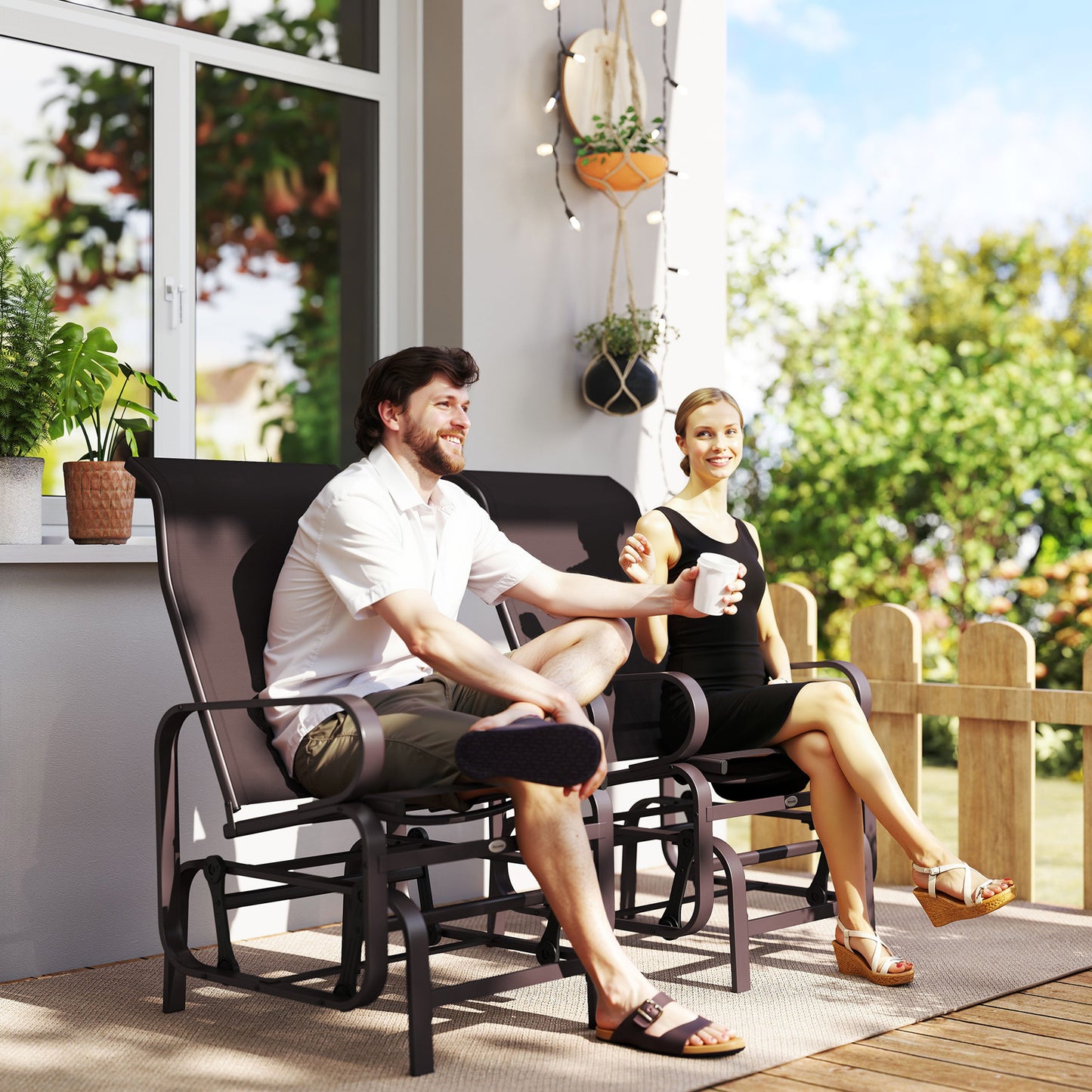 Outdoor gliding lounger chair with dark metal frame and mesh back and seat.