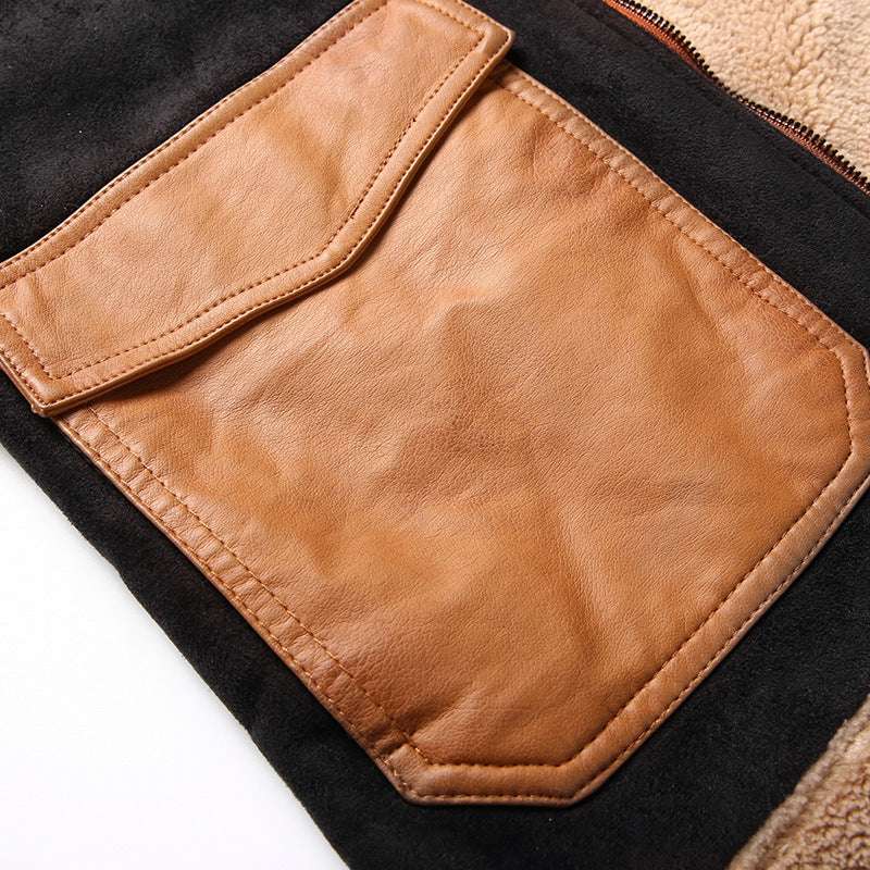 Close-up of a brown leather pocket on a black jacket with a white background