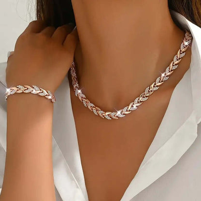 Rhinestone leaf necklace and bracelet set in rose gold tone, styled on model with chain details.
