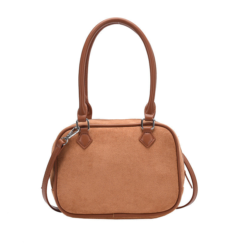 Tan suede crossbody handbag with top handles and adjustable shoulder strap