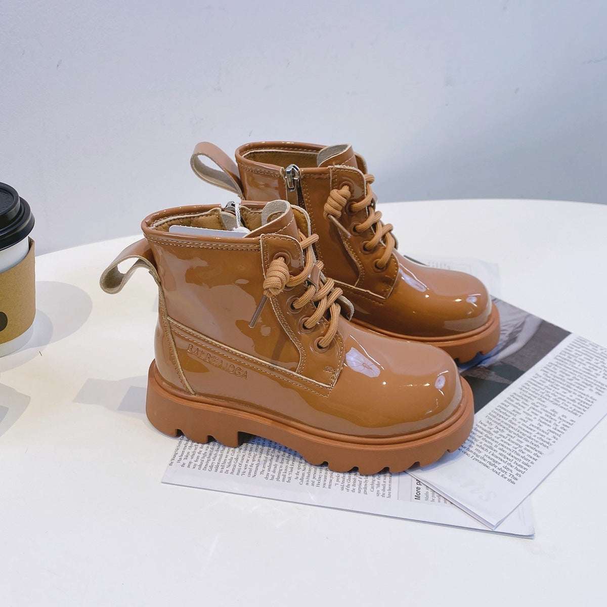 Brown glossy lace-up leather ankle boots with side zip, padded collar, and chunky sole