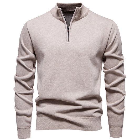 A man modeling a sophisticated navy blue half-zip knit sweater with a metallic zipper detail, layered over a white collared shirt.