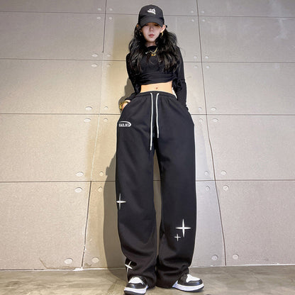 Black wide-leg sweatpants with ankle ties and white star-and-cross print