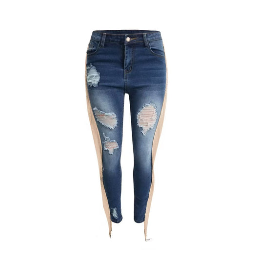 A woman modeling form-fitting pencil-style denim pants with intentional rips, distressed detailing, and decorative tassel fringe at the hem or side seams.