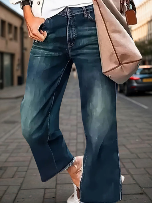 A woman modeling high-waisted wide-leg denim pants featuring a clean front with a built-in zipper closure and a flowing, voluminous leg.