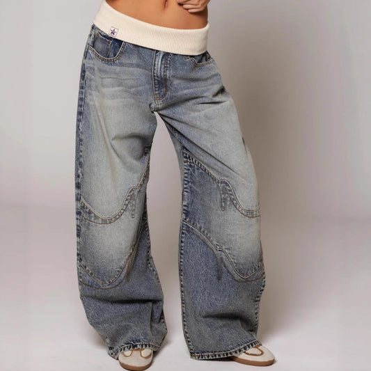 A woman modeling relaxed, loose-fitting straight-leg jeans with functional side pockets and a mid-rise waist, styled in a modern streetwear aesthetic.