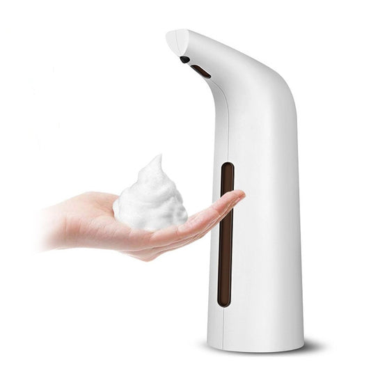 White soap dispenser dispensing soap onto a hand against a white background