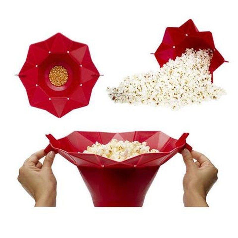 A red silicone popcorn bucket designed to be used in the microwave, shown in different states: closed with kernels, expanded with popped popcorn, and being handled by a person.