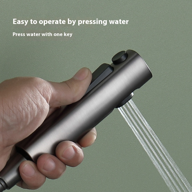 Hand holding a handheld shower head with water spraying out, against a green background.