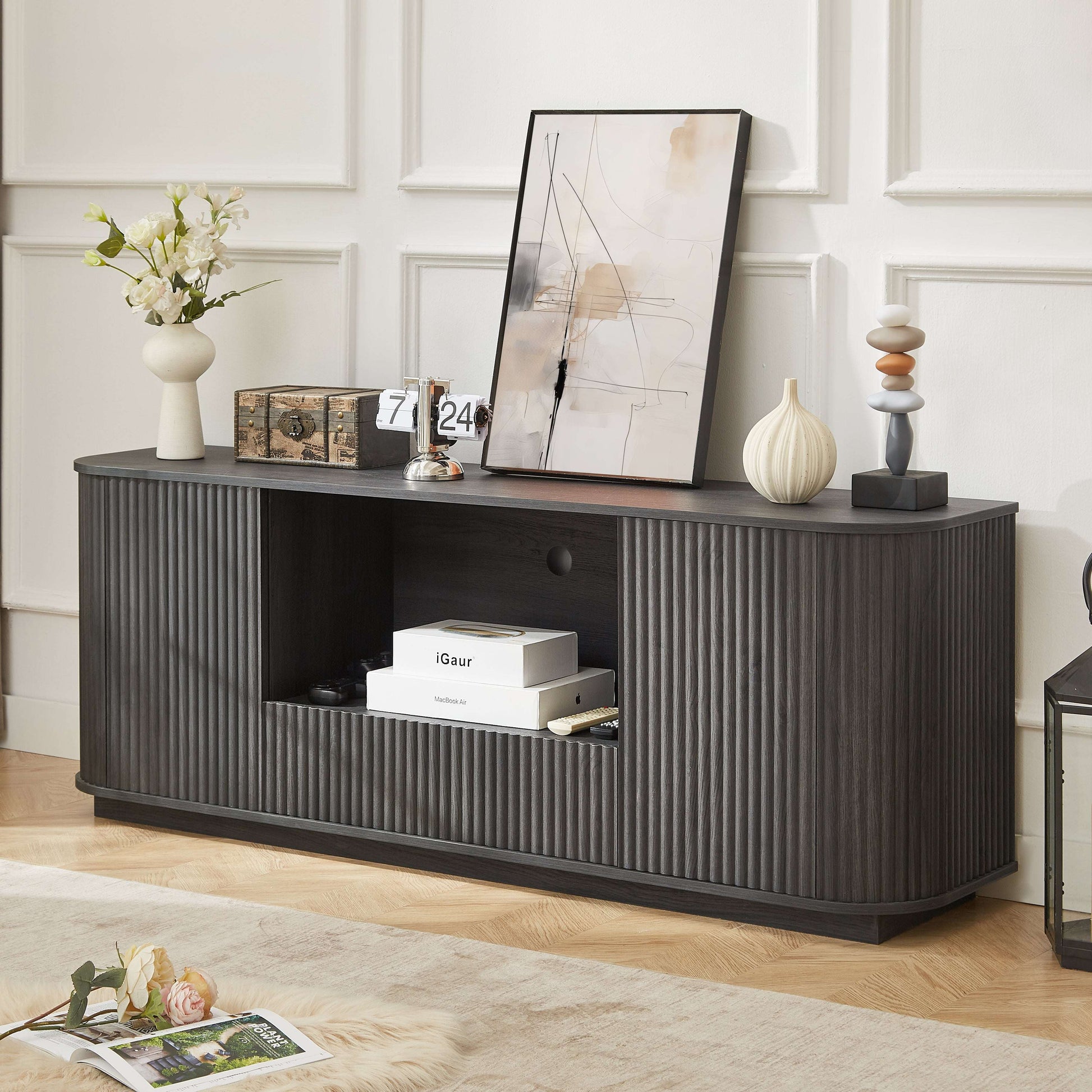 Black wavy TV stand with rounded corners, vertical ribbed doors and open center shelf