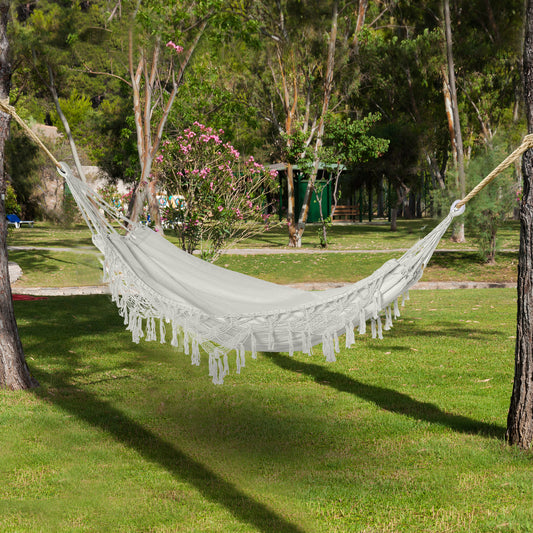 Elegant white extra large boho hammock with handmade macrame tassel fringe hanging on a sunny porch